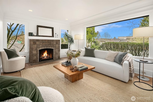 living area featuring a fireplace with flush hearth, wood finished floors, recessed lighting, and a wealth of natural light