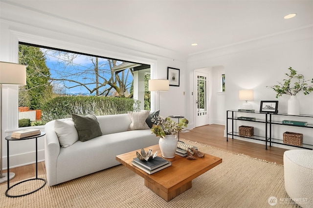 living room featuring recessed lighting, wood finished floors, baseboards, and arched walkways