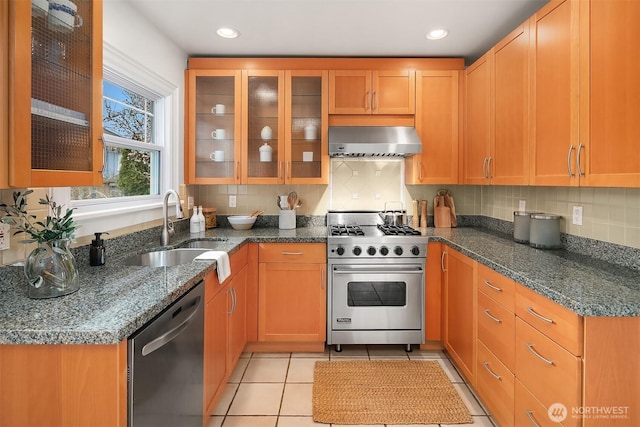 kitchen featuring a sink, stainless steel appliances, tasteful backsplash, and wall chimney exhaust hood