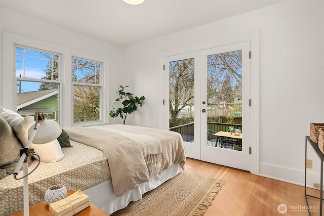 bedroom with access to exterior, french doors, light wood-type flooring, and baseboards