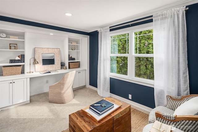 office with baseboards, light carpet, built in shelves, and built in desk