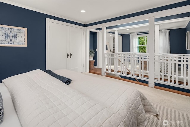 carpeted bedroom with a closet, recessed lighting, and crown molding