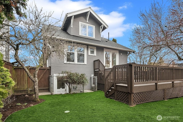 back of house with a yard, a deck, and fence