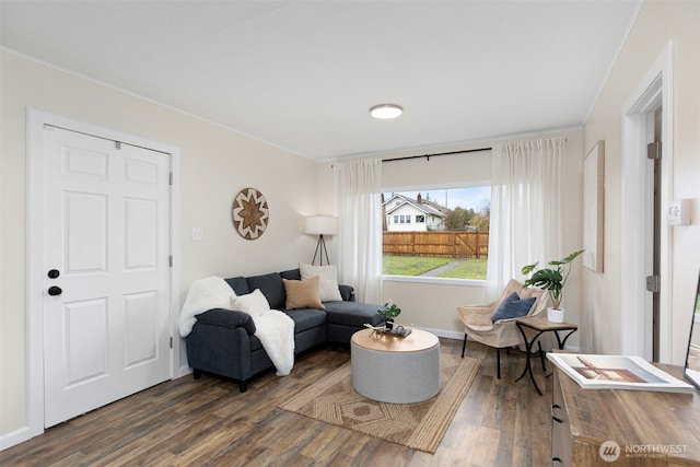 living room featuring baseboards, dark wood-style floors, and ornamental molding