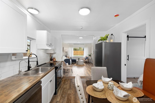 kitchen with appliances with stainless steel finishes, white cabinetry, wood counters, and dark wood-type flooring