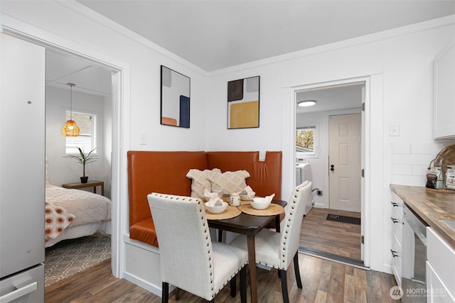 dining area featuring crown molding and dark wood-type flooring