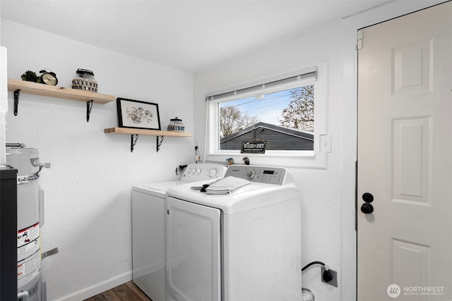 laundry room featuring dark wood-type flooring, water heater, separate washer and dryer, baseboards, and laundry area