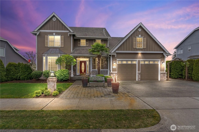 craftsman-style house with board and batten siding, driveway, and a shingled roof