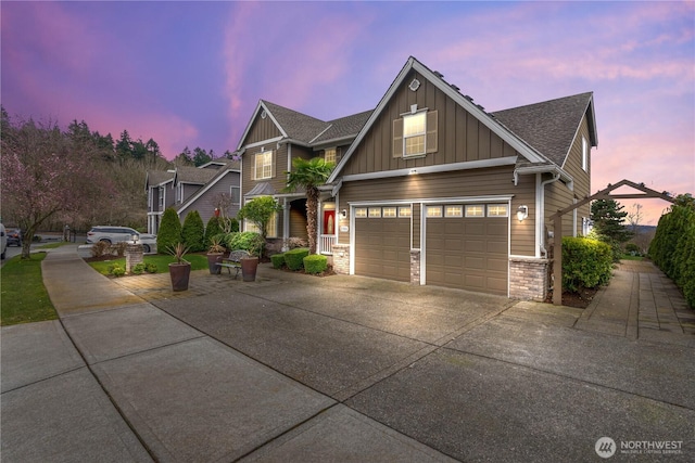 craftsman house featuring concrete driveway, brick siding, board and batten siding, and a shingled roof