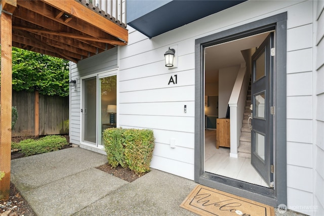 doorway to property featuring fence