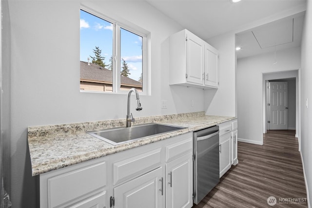 kitchen with dark wood-type flooring, baseboards, dishwasher, white cabinetry, and a sink