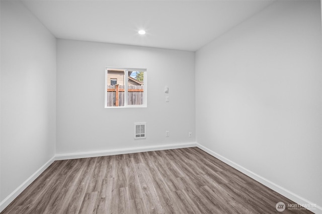 spare room featuring visible vents, recessed lighting, baseboards, and wood finished floors