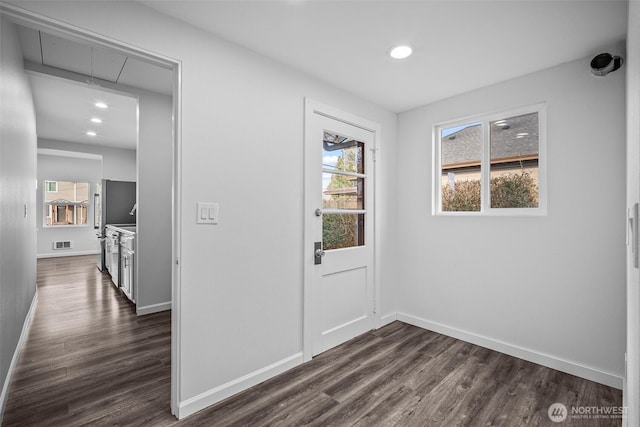 interior space featuring dark wood-style flooring, attic access, visible vents, and a wealth of natural light