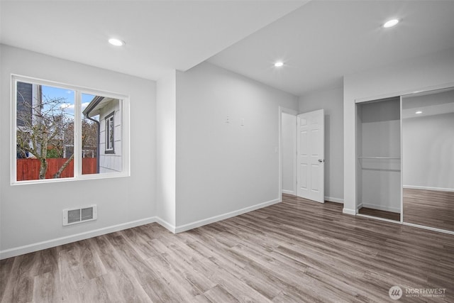 unfurnished bedroom with recessed lighting, visible vents, baseboards, and wood finished floors