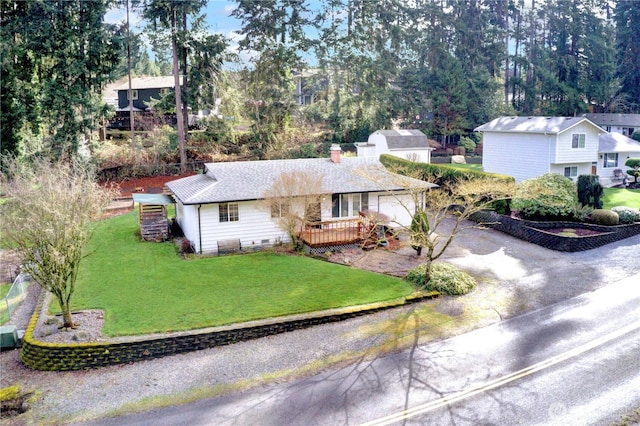 view of front of home featuring a front yard, a garage, driveway, and a chimney