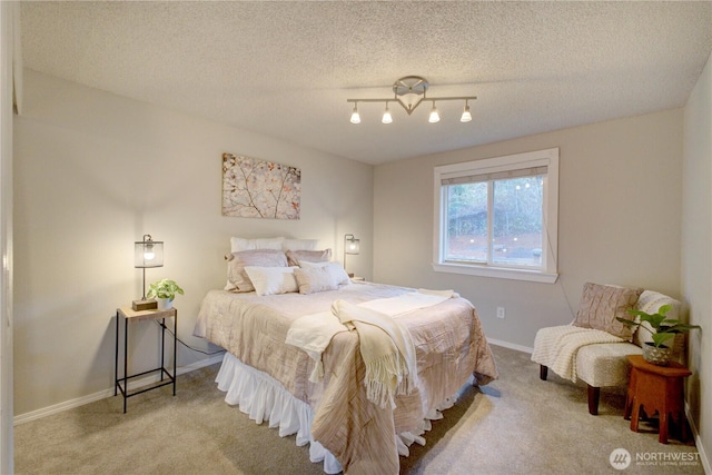 carpeted bedroom with a textured ceiling and baseboards