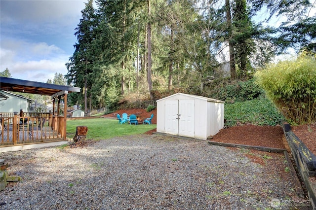 view of yard with a storage unit, an outbuilding, and a deck