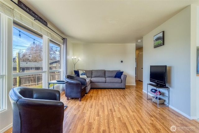 living area with baseboards and light wood-style flooring