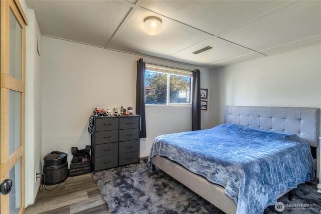 bedroom featuring visible vents and wood finished floors