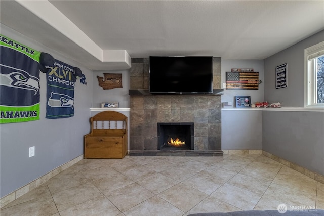 unfurnished living room with tile patterned floors, a fireplace, and baseboards