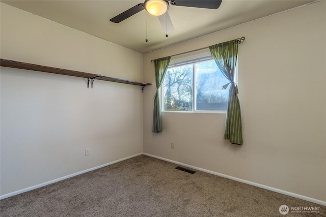 carpeted empty room with visible vents, a ceiling fan, and baseboards