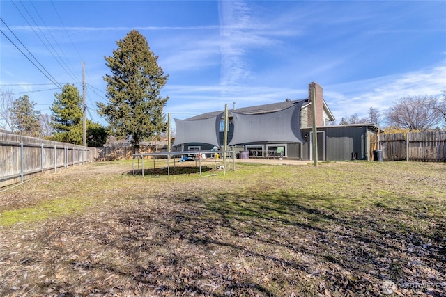 view of yard with a patio area, a trampoline, and a fenced backyard