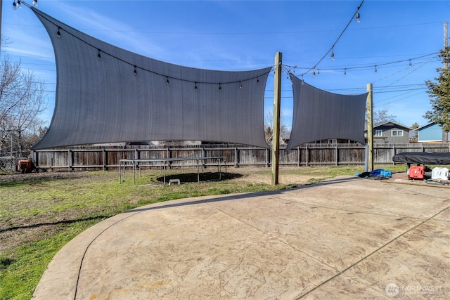 view of outbuilding with a trampoline and fence