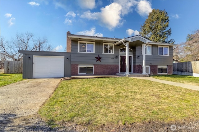 split foyer home featuring brick siding, an attached garage, and fence