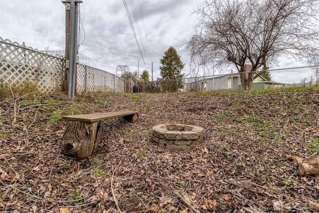 view of yard with an outdoor fire pit and fence