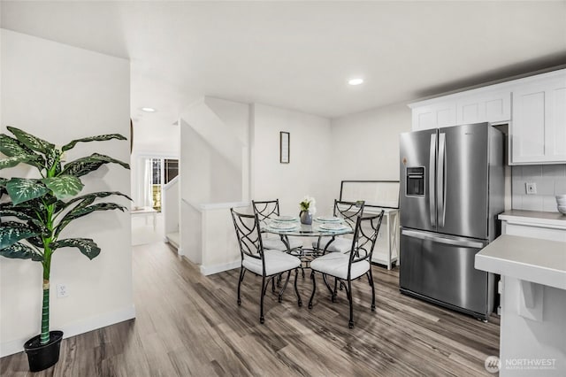 dining space with recessed lighting, stairs, baseboards, and wood finished floors