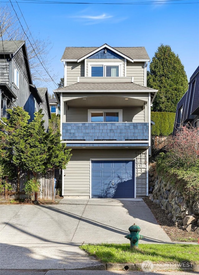 view of front of property with a balcony, an attached garage, fence, and driveway