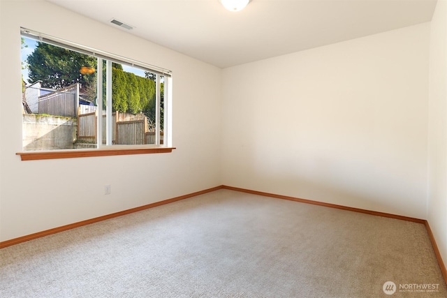 unfurnished room with visible vents, carpet floors, and baseboards