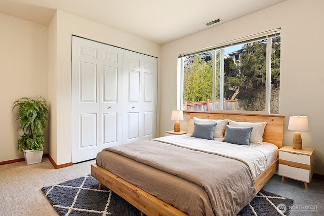 bedroom with a closet, visible vents, baseboards, and carpet floors