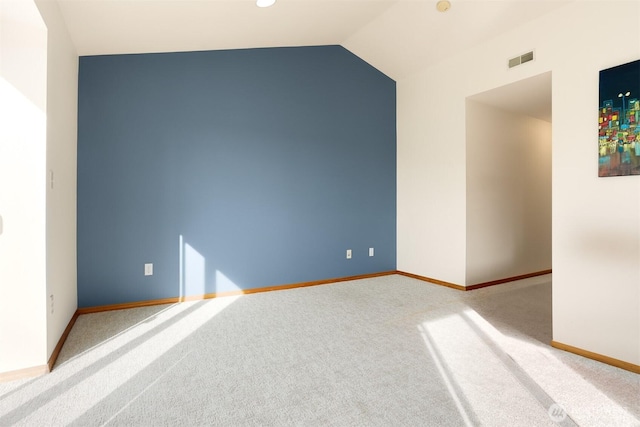 carpeted spare room featuring visible vents, baseboards, and lofted ceiling