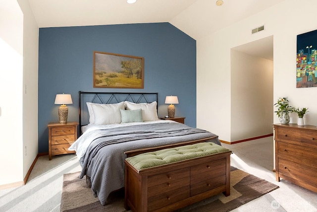 bedroom featuring vaulted ceiling, light colored carpet, visible vents, and baseboards