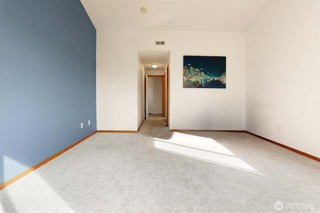 carpeted empty room featuring visible vents and baseboards