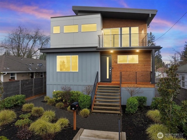 view of front of home featuring a balcony and fence