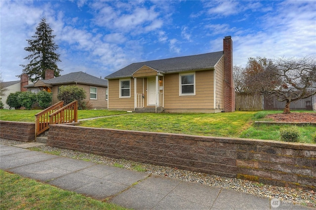 view of front of property featuring a chimney, a front yard, and fence