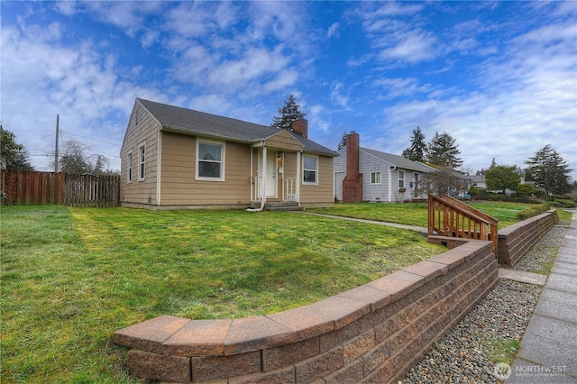 view of front of property with a front lawn and fence