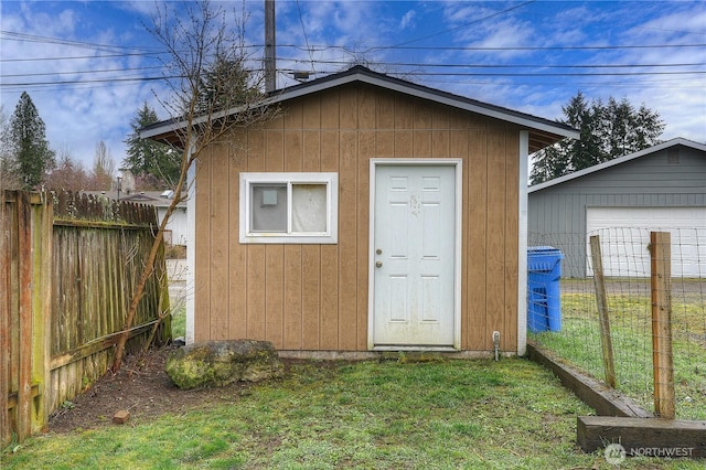 view of outdoor structure with an outbuilding and fence