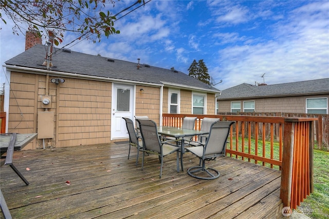 wooden terrace with outdoor dining area and fence