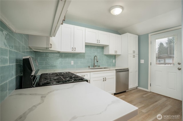 kitchen with light wood-type flooring, a sink, stainless steel dishwasher, gas stove, and decorative backsplash