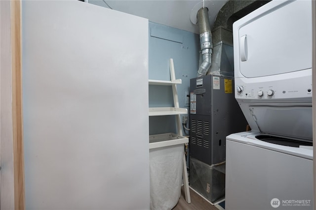 laundry area with laundry area, wood finished floors, and stacked washer and dryer