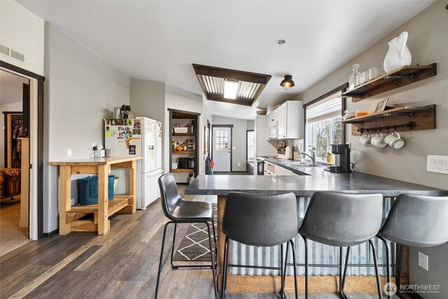 154 Dreamscape Rd, Walla Walla, WA 99362 - kitchen featuring visible vents, a kitchen bar, open shelves, white refrigerator with ice dispenser, and stove