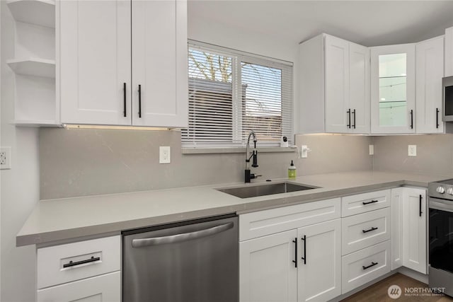 kitchen with open shelves, stainless steel appliances, a sink, light countertops, and white cabinets