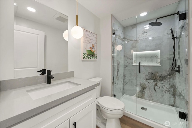 full bathroom with recessed lighting, a marble finish shower, toilet, and vanity