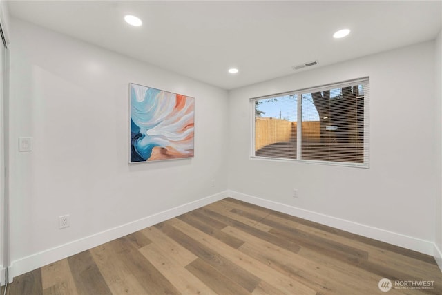 spare room with recessed lighting, visible vents, baseboards, and wood finished floors