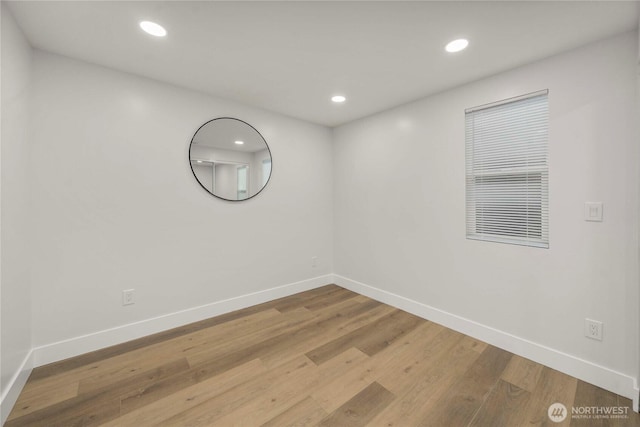 unfurnished room with recessed lighting, wood finished floors, and baseboards