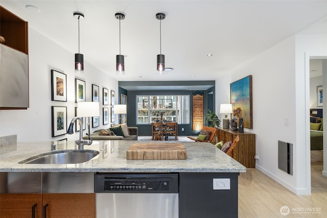 kitchen with light stone countertops, visible vents, a sink, stainless steel dishwasher, and open floor plan