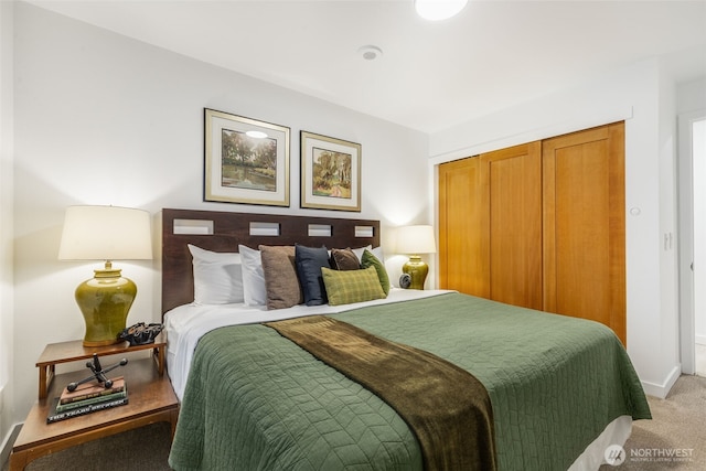 bedroom with baseboards, a closet, and light carpet